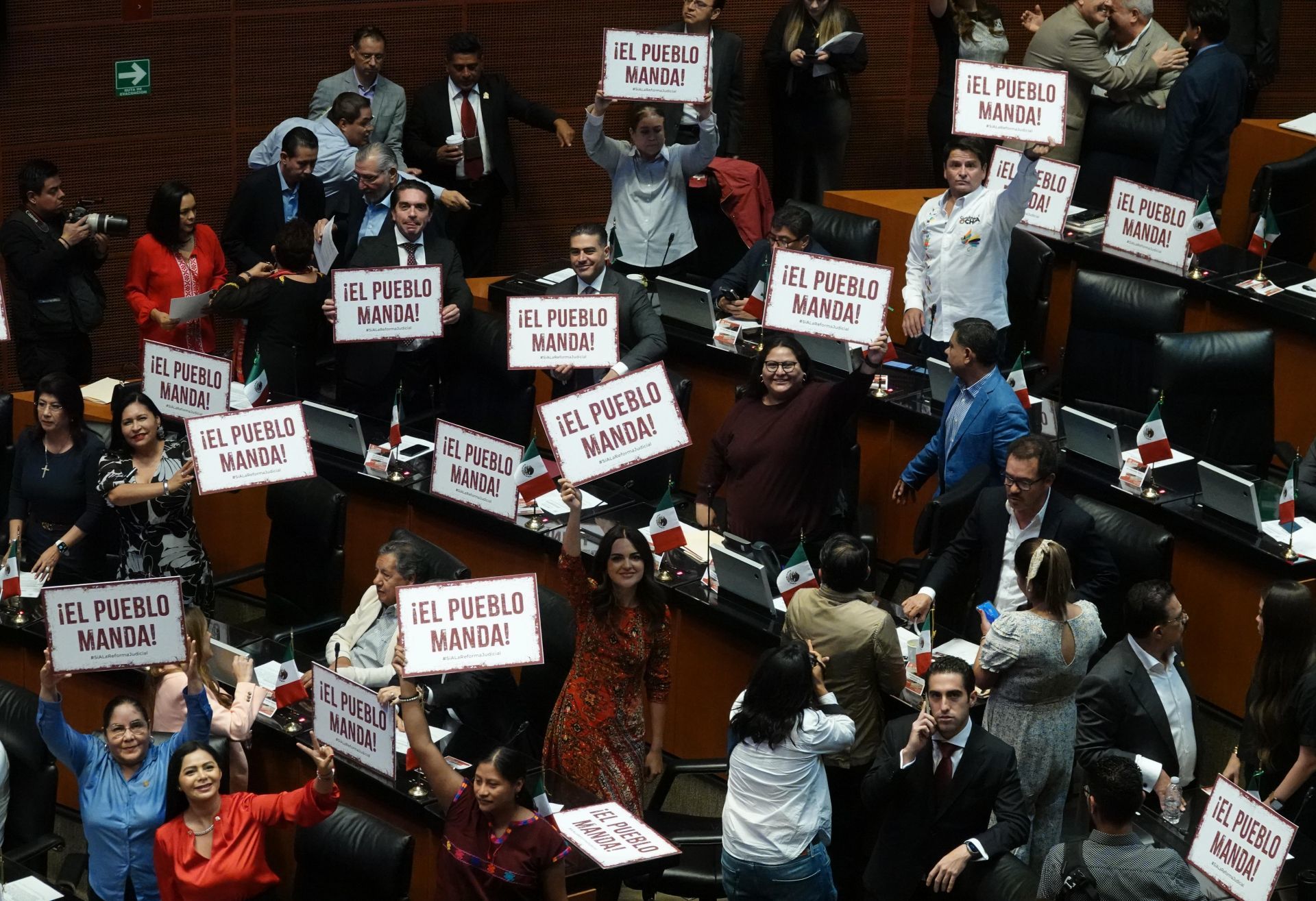 La bancada morenistas sostiene pancartas con la leyenda 