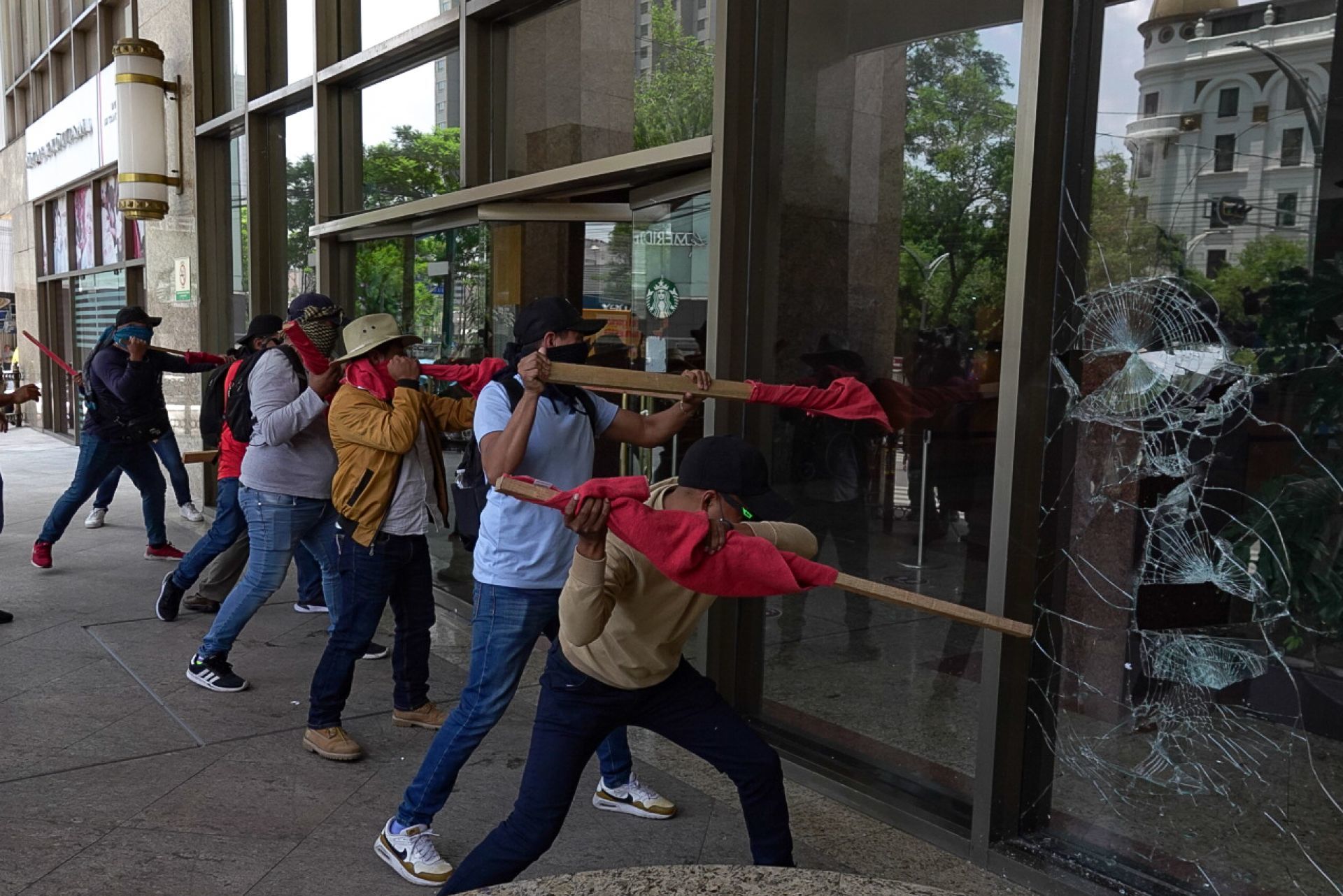 Integrantes de la CNTE rompiendo la entrada en la Torre del Bienestar durante su protesta rumbo al Zócalo. (Cuartoscuro)
