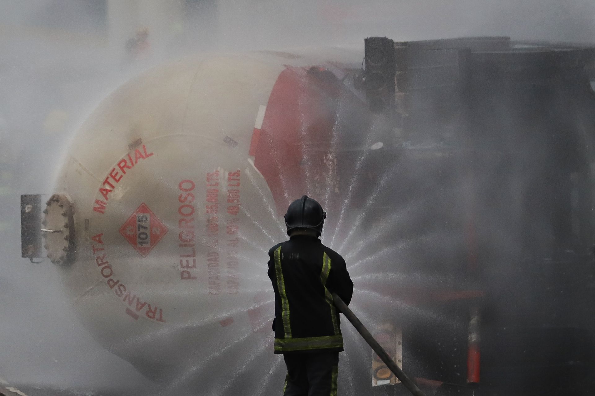 Un bombero intenta sofocar el fuego que generó el flamazo de una nube de gas LP. (Cuartoscuro)